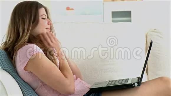 在笔记本电脑上看电影的年轻女子视频的预览图