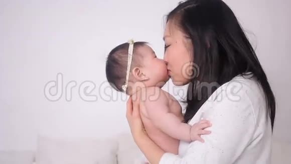 年轻的母亲亲吻小女儿视频的预览图
