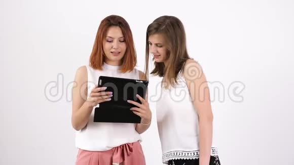 穿着白色墙壁的女人用平板电脑视频的预览图