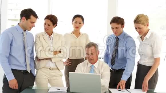 商务团队在笔记本电脑前然后指向相机视频的预览图