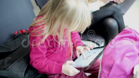 女儿和母亲正在平板电脑和手机上打字等待飞机视频的预览图
