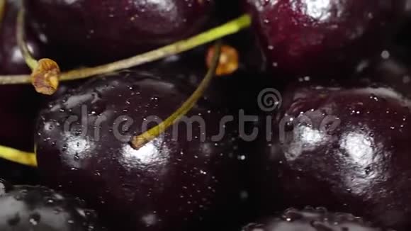 樱桃成熟的樱桃在黑色背景上旋转旋转黑色成熟甜樱桃旋转4KUHD视频无缝视频的预览图