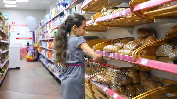 在超市买烘焙食品面包的少女视频的预览图