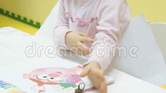 一个小女孩坐在幼儿园的椅子上视频的预览图
