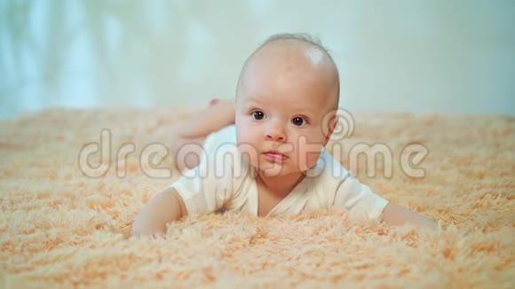 婴儿趴在舒适的地毯上视频的预览图
