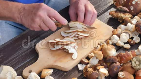 男人用菜刀仔细清洗野生蘑菇手拿蘑菇从茎中取出粘土或根视频的预览图