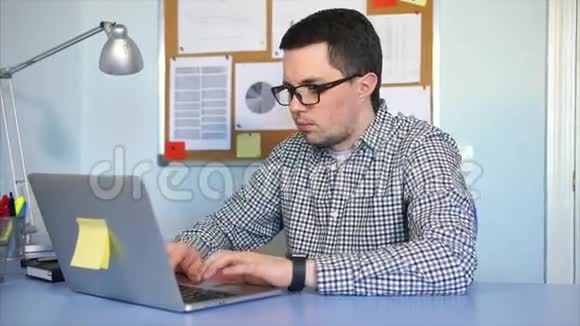 商人坐在办公室的桌子上用笔记本电脑工作视频的预览图