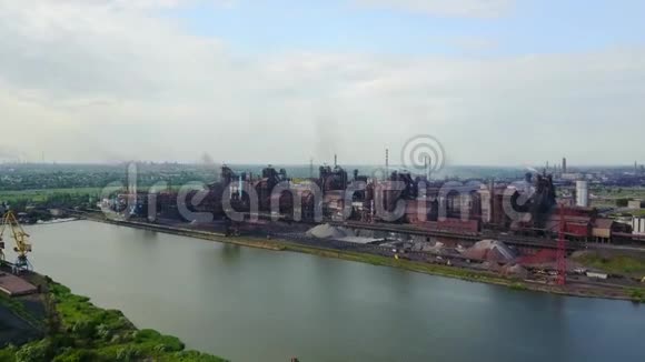 从靠近海洋的冶金厂看到空气大气和河水污染的工业化城市上空视频的预览图