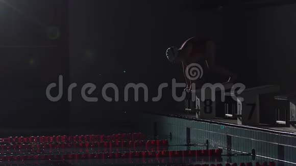 男游泳运动员从起点跳下来开始在游泳池里游泳职业运动员训练潜水和溅水视频的预览图