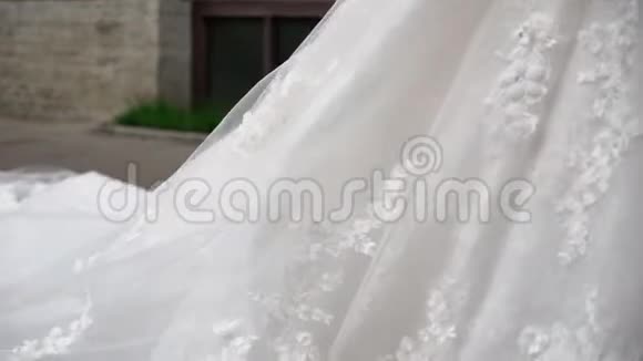 年轻的新娘穿着婚纱在城市里散步白色豪华礼服视频的预览图