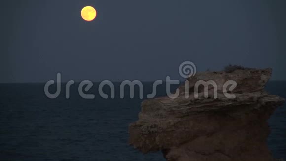 明亮的黄色月亮岩石和海洋视频的预览图