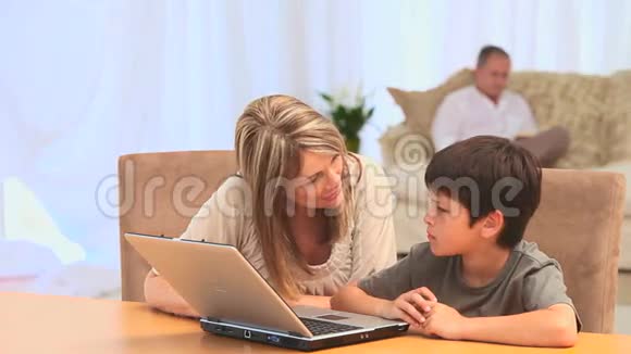 带孙子的女人用笔记本电脑视频的预览图