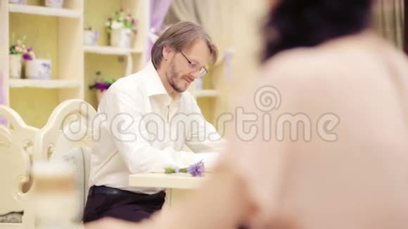 一个戴眼镜的年轻人的肖像男人摘下眼镜看着那个女人视频的预览图