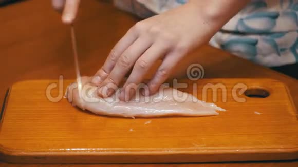 手切鲜肉在厨房板上切鸡片切生肉视频的预览图