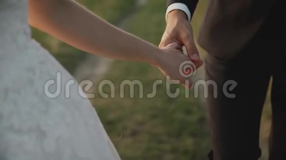 日落时在田野里的情人女孩和男人牵手快乐的一对微笑视频的预览图