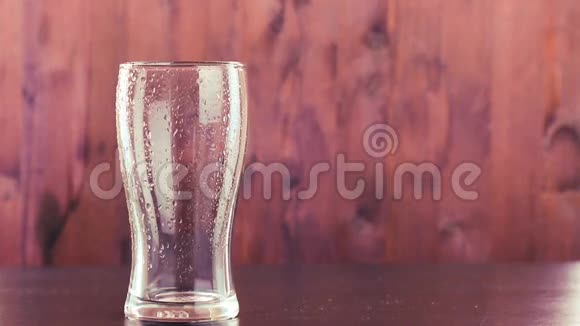 把啤酒倒在玻璃里在木头上涂上白色泡沫视频的预览图