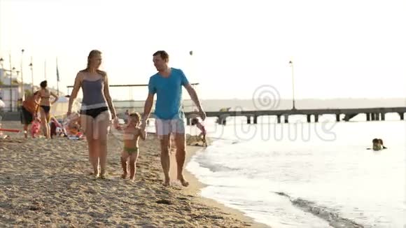 年轻夫妇在海边和儿子玩耍视频的预览图