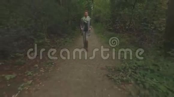 一名年轻女子在森林中行走低空跟踪后射视频的预览图