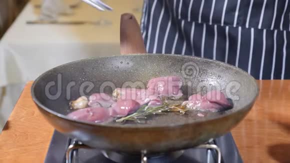 在餐厅的一个热煎锅上加入肝片的厨师烹饪弗拉姆贝式菜肴慢动作视频的预览图
