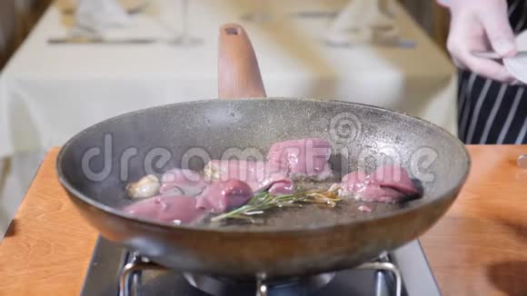 在餐厅的一个热煎锅上加入肝片的厨师烹饪弗拉姆贝式菜肴慢动作视频的预览图