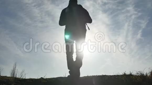 剪影阳光游客徒步旅行者背着背包从山顶欣赏日落景色徒步旅行者的剪影视频的预览图