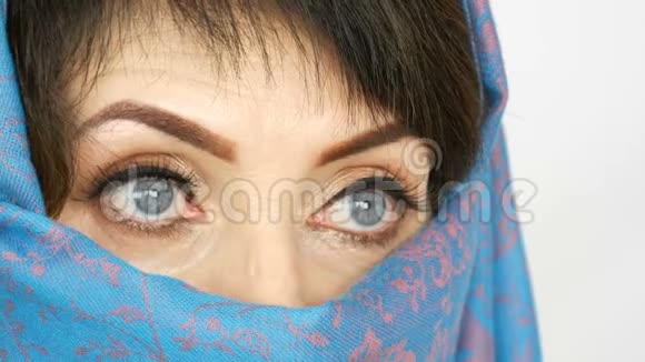 一位阿拉伯中年成年妇女的肖像她有着不寻常的美丽的蓝色大眼睛传统的睫毛很长视频的预览图