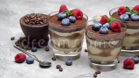 经典的提拉米苏甜点蓝莓和覆盆子放在杯子里碗里放浆果视频的预览图