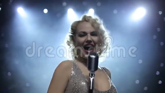 女歌手在烟雾弥漫的舞台上背光视频的预览图