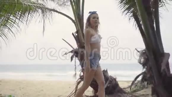 在棕榈树之间美丽的夏日美丽自然的女人视频的预览图