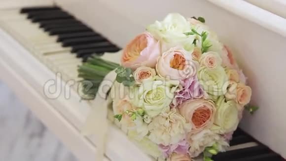 结婚的花躺在钢琴的琴键上视频的预览图