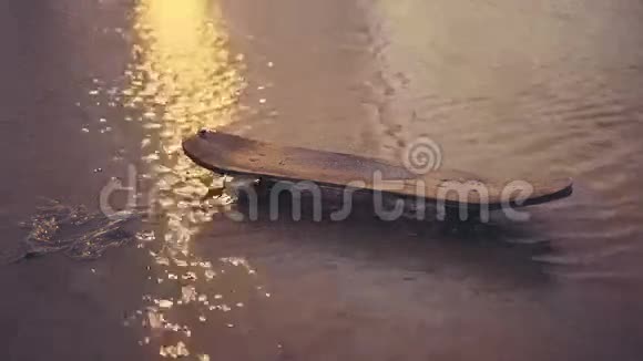 旧滑板在肮脏的水坑里视频的预览图