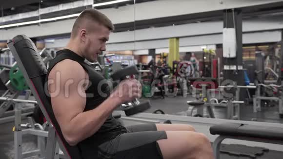 男运动员用哑铃训练二头肌视频的预览图