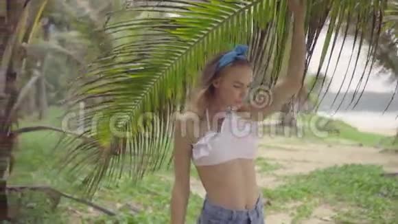 在棕榈树之间美丽的夏日美丽自然的女人视频的预览图