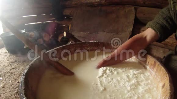 手从一个大锅中挑选热奶酪这是山的古老传统视频的预览图