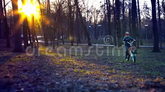 在日落公园骑自行车的小男孩视频的预览图