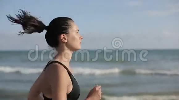 一个女人独自在美丽的日落海滩上奔跑视频的预览图