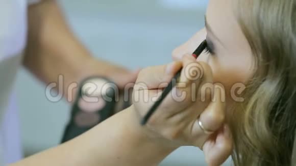 专业化妆师将色调粉涂在金发模特眼皮上做眼影视频的预览图