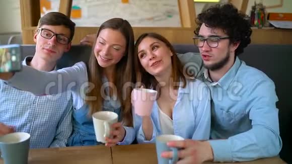 微笑的朋友坐在咖啡馆里玩得开心交流自拍视频的预览图