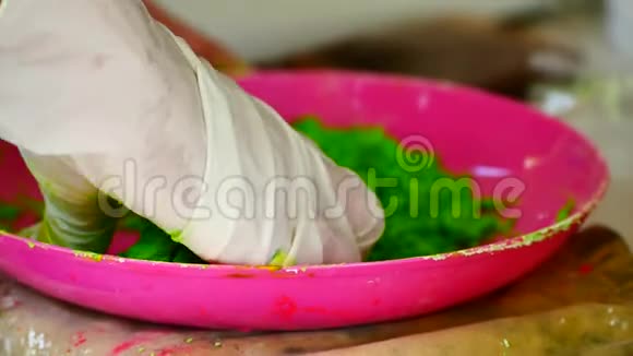 如何制作彩粉冬青节手在腌制食用色素与玉米淀粉混合制成面粉颜色和干燥视频的预览图