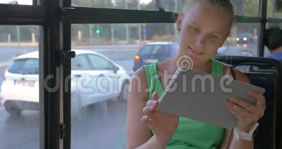女人在公共汽车里用平板电脑视频的预览图
