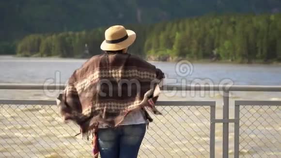旅行者的女人沿着斜拉桥穿过山河视频的预览图