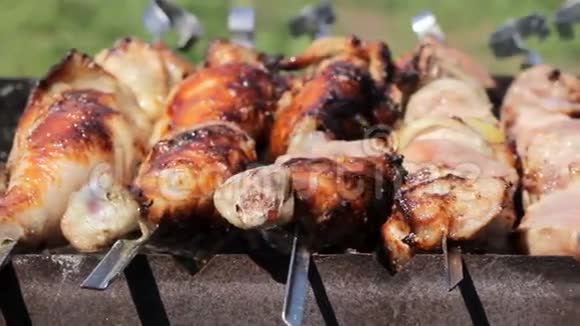 鸡肉和猪肉在烧烤中用木炭烤肉旋转有金黄色的皮肤移动摄像机关门视频的预览图