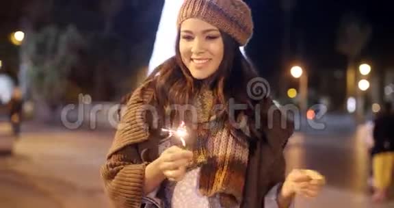 一个漂亮的年轻女人在用火花庆祝视频的预览图