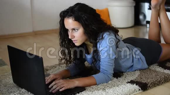 带手提电脑的女孩躺在客厅里视频的预览图