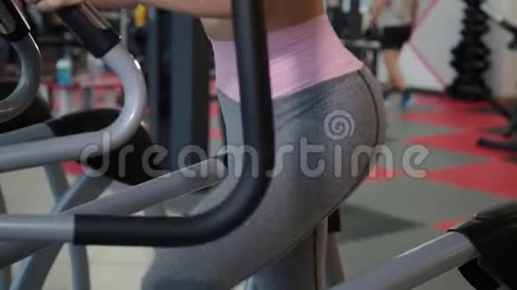 漂亮的运动年轻女孩在健身房训练椭圆教练视频的预览图