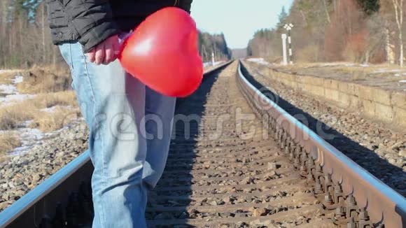 铁路上有红色心形气球的人视频的预览图