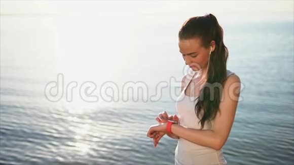 年轻漂亮的女人用智能手表视频的预览图