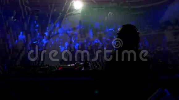 一位女性DJ在拥挤的俱乐部里混合音乐的录像视频的预览图