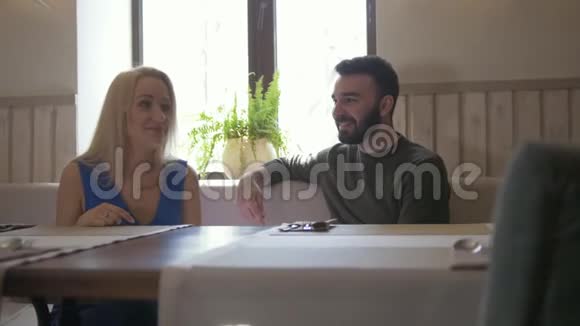 快乐的白种人夫妇在咖啡馆吃菜单视频的预览图
