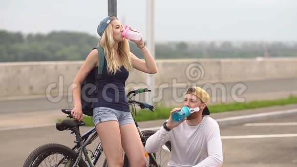 年轻夫妇在城里骑自行车慢动作视频的预览图